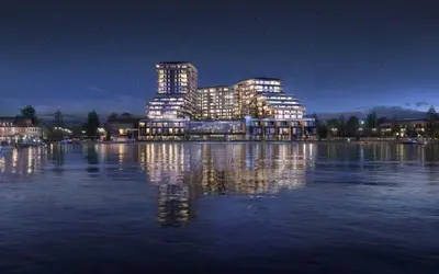 a lit up building on the water at night at Beach Lake Resort in Kelowna
