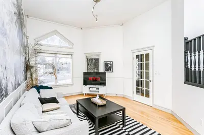 a white living room with a couch and a table at Chic Central 4BDRM Home-King Bed-AirHockey-Mins DT in Edmonton