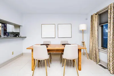 a dining room with a wooden table and white chairs at Chic Central 4BDRM Home-King Bed-AirHockey-Mins DT in Edmonton