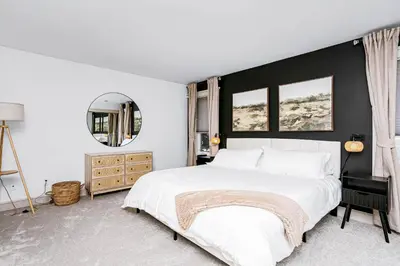 a bedroom with a white bed and a black wall at Chic Central 4BDRM Home-King Bed-AirHockey-Mins DT in Edmonton