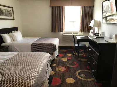 a hotel room with two beds and a desk at Stonebridge Hotel in Fort McMurray