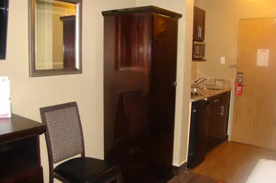 a kitchen with a large brown refrigerator in a room at Stonebridge Hotel in Fort McMurray
