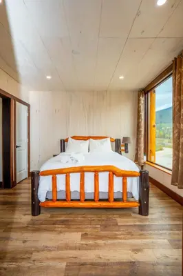 a large bed in a room with a large window at River Safari Bear Den in Blue River