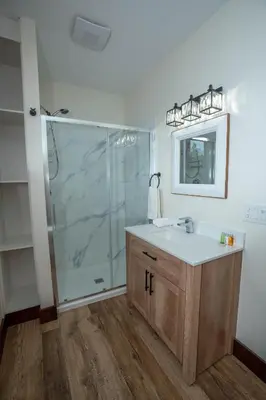 a bathroom with a shower and a sink and a mirror at River Safari Bear Den in Blue River