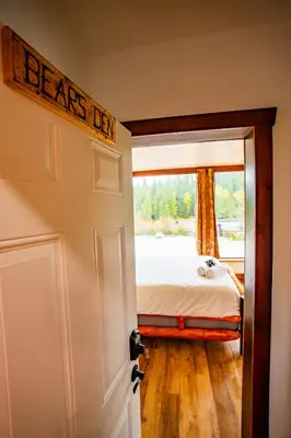 a bedroom with a bed and a door with a sign that reads dreams den at River Safari Bear Den in Blue River