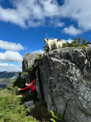 a person standing on a rock with a goat on it at Peaks & Waters at Harrison Mills in Agassiz