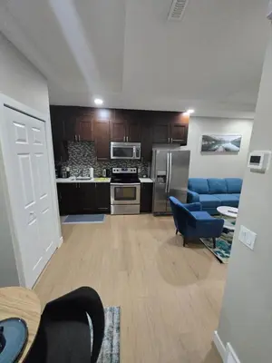 a living room with a blue couch and a kitchen at 2 Bedroom Secondary Suite in Calgary
