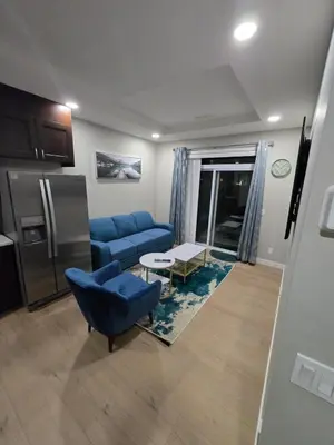 a living room with a blue couch and a refrigerator at 2 Bedroom Secondary Suite in Calgary