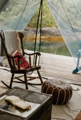 a rocking chair in a room with a window at Lux Remote Glamping Hideaway in Ucluelet