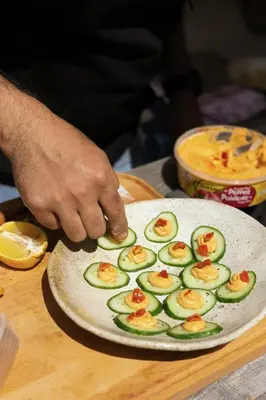 a person is making a dish with avocado on a plate at Lux Remote Glamping Hideaway in Ucluelet