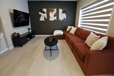 a living room with a brown couch and a table at Edgemont Retreat, Groups, River Cree, WEM, Disney in Edmonton