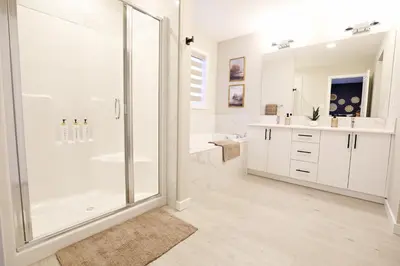 a white bathroom with a shower and a sink at Edgemont Retreat, Groups, River Cree, WEM, Disney in Edmonton