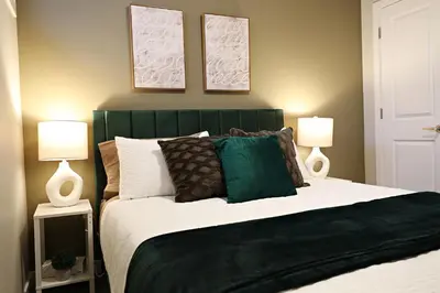 a bedroom with a large bed with two lamps at Edgemont Retreat, Groups, River Cree, WEM, Disney in Edmonton