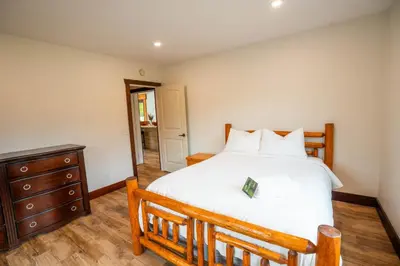 a bedroom with a large bed and a wooden dresser at River Safari Eagles Nest in Blue River