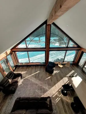 a living room with a large group of windows at River Safari Eagles Nest in Blue River