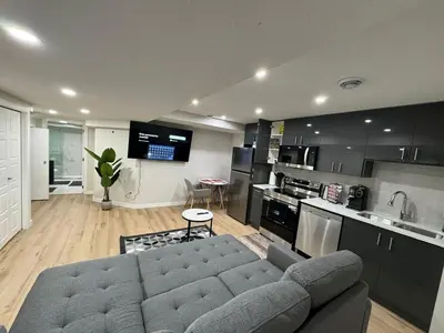 a living room with a couch and a kitchen at DJoshuas place in Edmonton