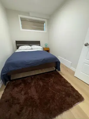 a bedroom with a bed and a brown rug at DJoshuas place in Edmonton