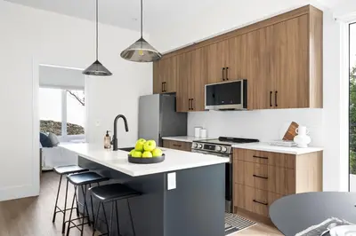 a kitchen with white countertops and wooden cabinets at Mountain Suite - Ocean View Fire Pit - Fully Equipped Kitchen - WD in Nanaimo