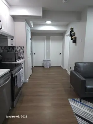 a hallway of a room with a kitchen and a couch at Lovely home in Northwest Calgary in Calgary