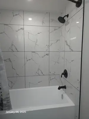 a bathroom with a shower with white marble tiles at Lovely home in Northwest Calgary in Calgary