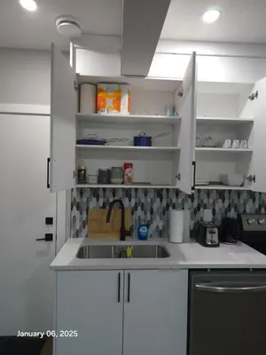 a kitchen with white cabinets and a sink at Lovely home in Northwest Calgary in Calgary