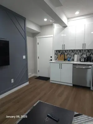 a kitchen with white cabinets and a sliding door at Lovely home in Northwest Calgary in Calgary