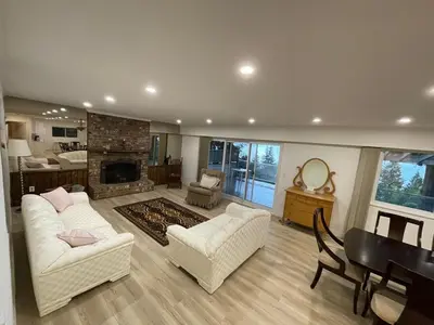 a living room with two white couches and a fireplace at Lionsbay in Lions Bay