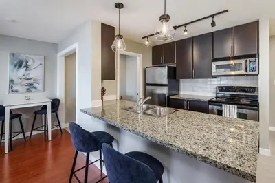 a kitchen with a counter and some blue bar stools at Cozy Condo! Central Location! Plus One Free Parking! in Vancouver