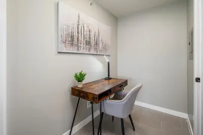 a desk with a chair and a lamp on a wall at Cozy Condo! Central Location! Plus One Free Parking! in Vancouver