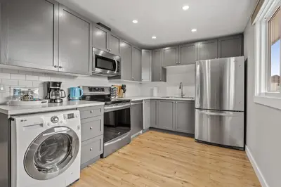 a kitchen with stainless steel appliances and a washer and dryer at Comfy, Cozy, Central Calgary, 2BR and 1BTH in Calgary