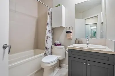 a bathroom with a toilet and a sink and a tub at Comfy, Cozy, Central Calgary, 2BR and 1BTH in Calgary