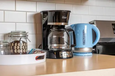 a coffee maker and a blue coffee mug on a counter at Comfy, Cozy, Central Calgary, 2BR and 1BTH in Calgary