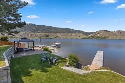 a view of a lake with a dock and a boat at Skaha Lakefront Inn in Okanagan Falls