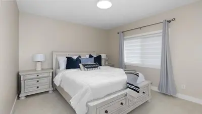 a white bedroom with a bed and a window at Skaha Lakefront Inn in Okanagan Falls