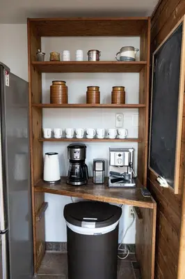 a kitchen with a shelf with a coffee maker and a coffee pot at First Light - Waterfront, Hot tub, Sauna, EV in Tofino