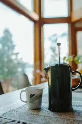 a coffee pot and a cup on a table at First Light - Waterfront, Hot tub, Sauna, EV in Tofino