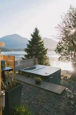 a picnic table in front of a body of water at First Light - Waterfront, Hot tub, Sauna, EV in Tofino