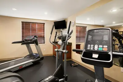 a room with a gym with a treadmill and a cell phone at Ramada by Wyndham Edson in Edson