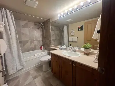 a bathroom with a sink and a tub and a toilet at Main Village, Ski-in Ski-out, Hot Tub, Condo in Sun Peaks
