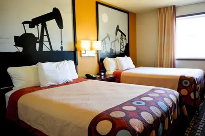 a hotel room with two beds and a camera on the wall at Super 8 by Wyndham Fox Creek in Fox Creek