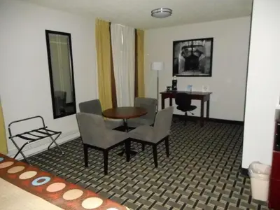 a room with a table and chairs and a desk at Super 8 by Wyndham Fox Creek in Fox Creek