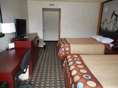 a hotel room with two beds and a desk at Super 8 by Wyndham Fox Creek in Fox Creek
