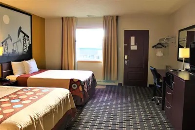 a hotel room with two beds and a television at Super 8 by Wyndham Fox Creek in Fox Creek
