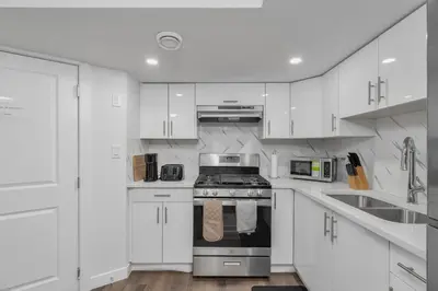 a kitchen with white cabinets and a stove top oven at Private Chic Orchard Getaway in Edmonton