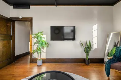 a living room with a tv on a wall with plants at The Accountant - Sleeps 3 Guests - DT Drumheller in Drumheller