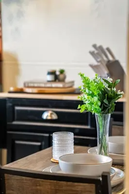 a table with a vase of flowers on a counter at The Accountant - Sleeps 3 Guests - DT Drumheller in Drumheller