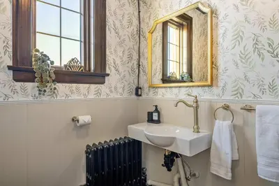 a bathroom with a sink and a mirror and a radiator at The Accountant - Sleeps 3 Guests - DT Drumheller in Drumheller