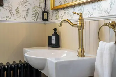 a bathroom with a white sink and a gold faucet at The Accountant - Sleeps 3 Guests - DT Drumheller in Drumheller