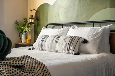 a bed with white pillows on it in a bedroom at The Accountant - Sleeps 3 Guests - DT Drumheller in Drumheller