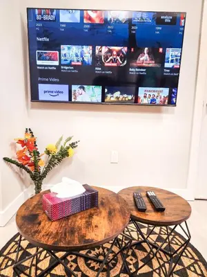 a table with two remote controls and a tv at Calgary Cozy Nest 2BR Suite in Calgary